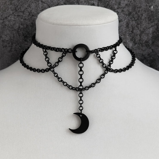 Black chain choker necklace with a crescent moon pendant on a mannequin.
