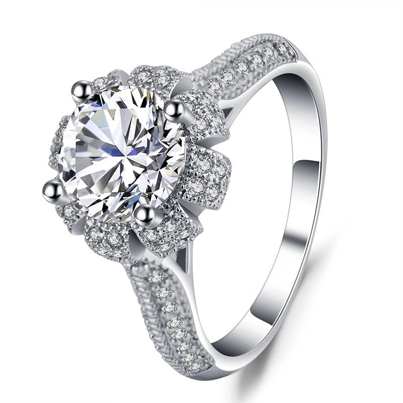 A silver-colored couple's ring with a large central zirconia and smaller micro-inlaid zircon stones around the edge.