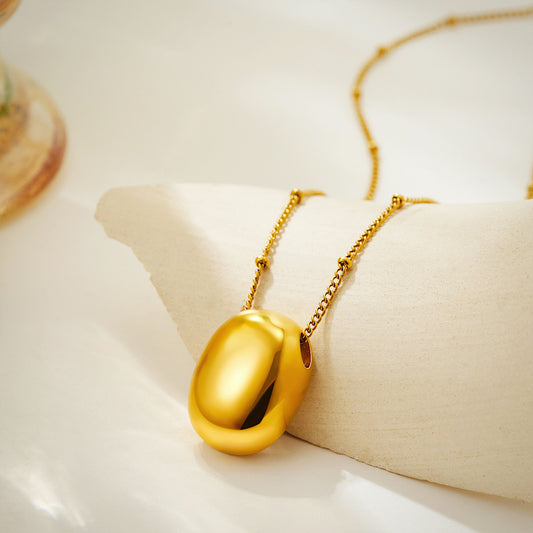 Gold plated pendant necklace with a chain link display with aesthetic background