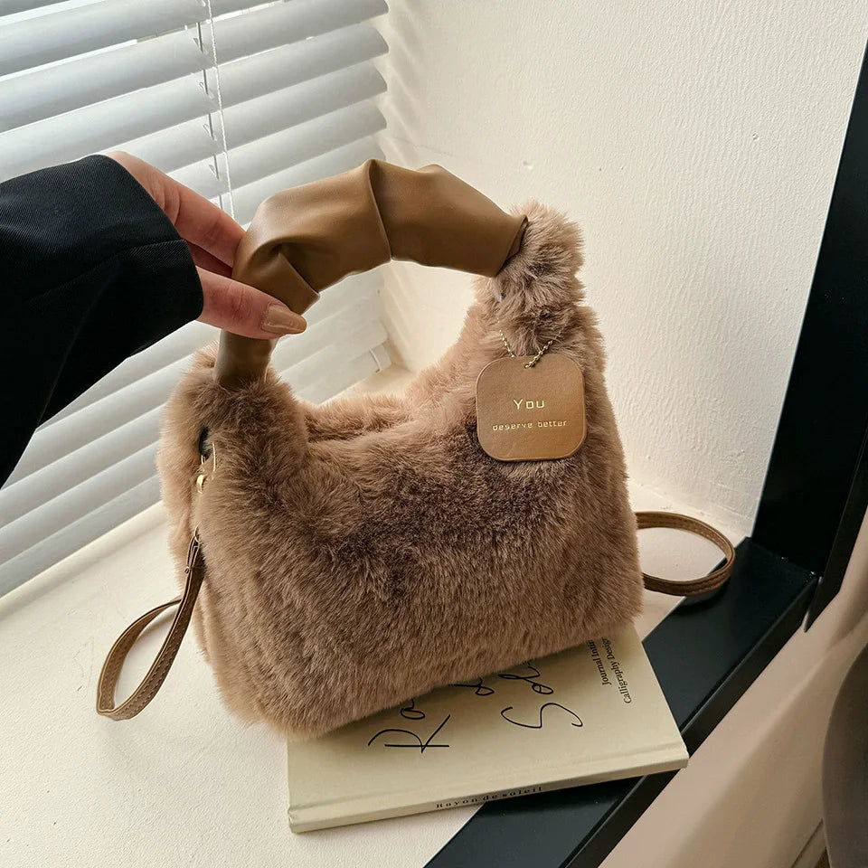 Brown fluffy handbag with a visible brand tag on a surface. MYH