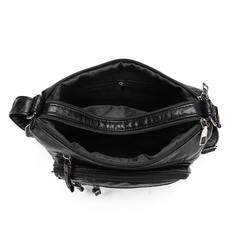 Black leather bag with multiple zippers on a white background