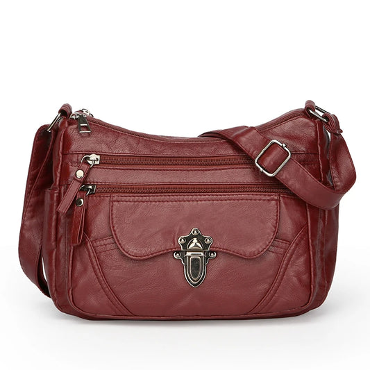 Red leather handbag with gold accents on a white background