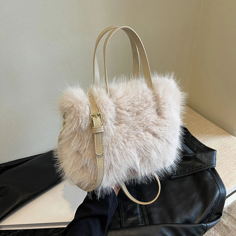 Beige fur handbag with a gold buckle on a black leather jacket.