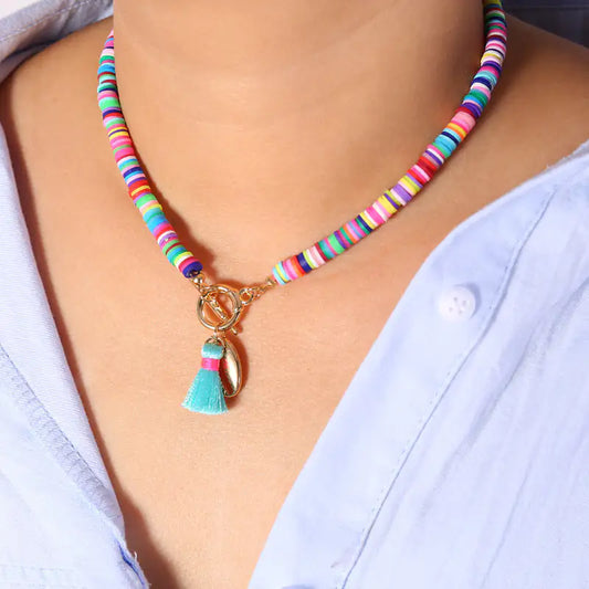 Boho shell necklace with multicolor ceramic beads and tassel charm – styled on neck and flat lay.