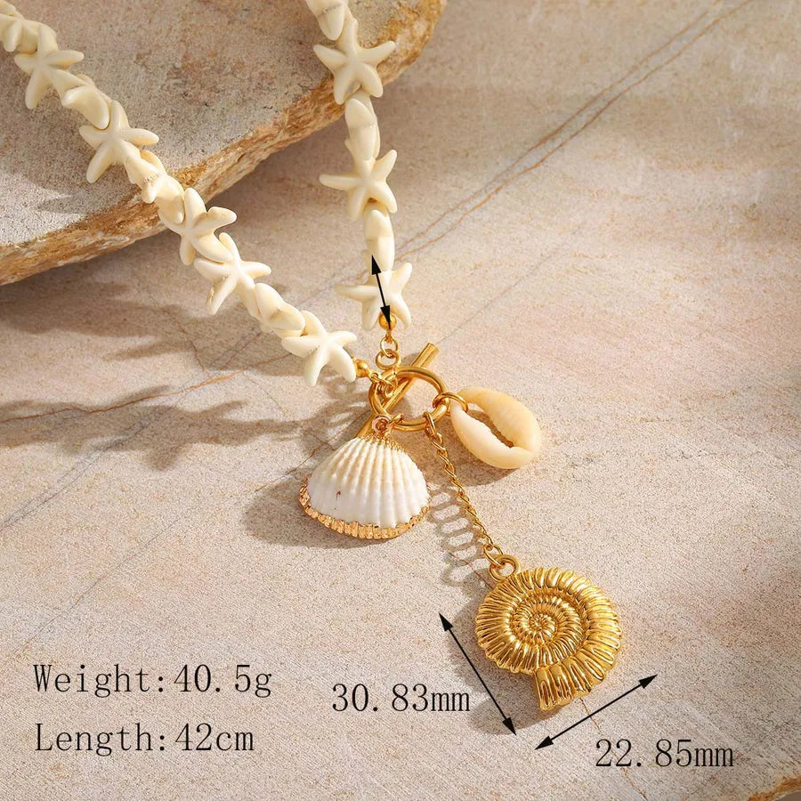 Detail view of conch and shell charms in 18K gold plated finish with dimensions