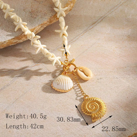Detail view of conch and shell charms in 18K gold plated finish with dimensions