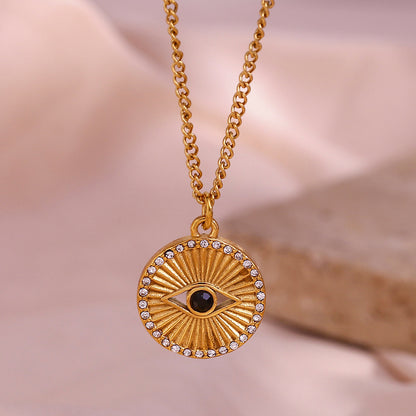 Minimalist gold coin necklace with black eye rhinestone and rising sun design on stainless steel chain