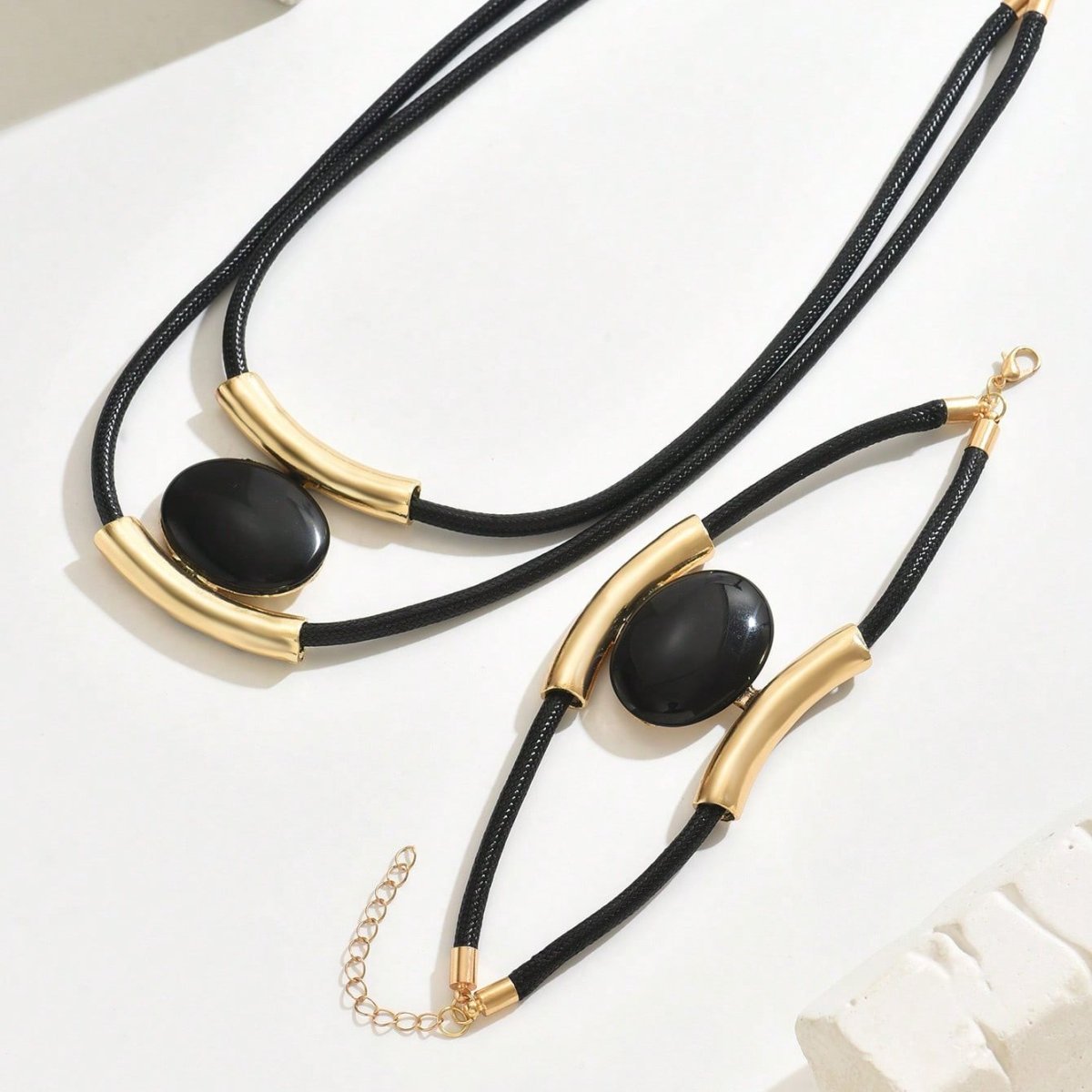 Necklace with black stones and gold accents on a white background