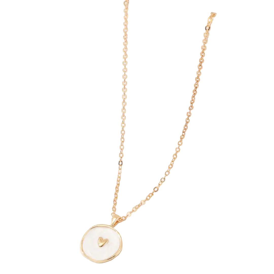 Gold necklace with a heart pendant on a white surface