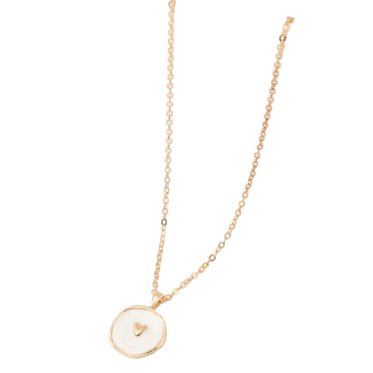 Gold necklace with a heart pendant on a white surface