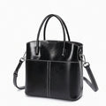 Black leather handbag with a shoulder strap on a white background