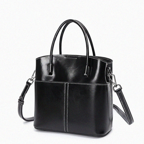 Black leather handbag with a shoulder strap on a white background