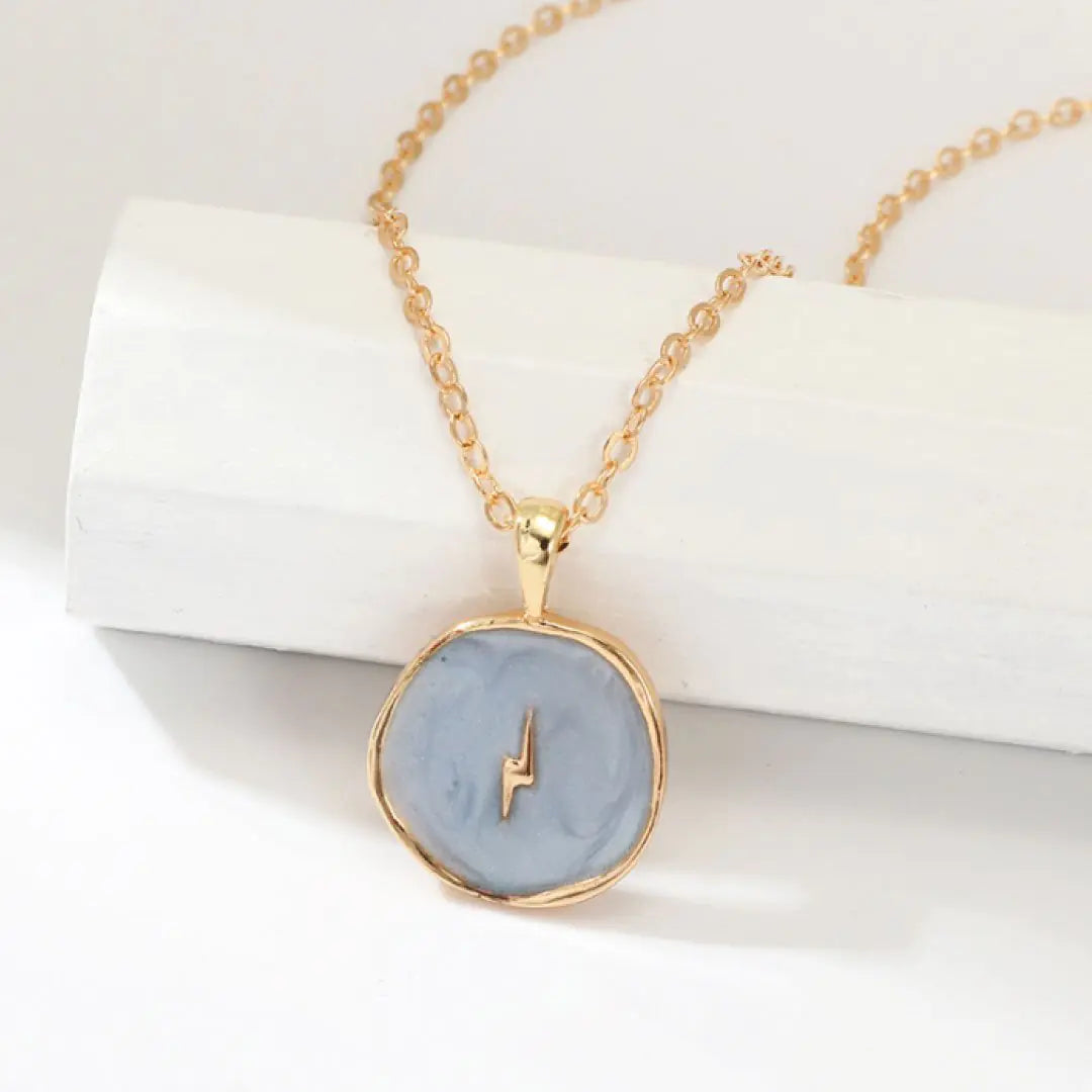Necklace with a blue pendant and gold chain on a white background