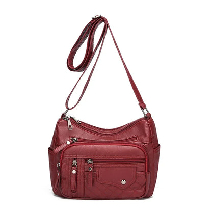 Red handbag with multiple pockets and a shoulder strap on a white background