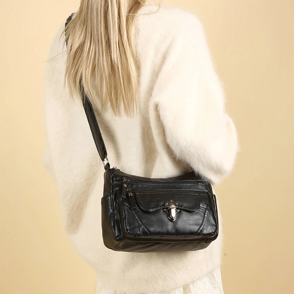 Person wearing a black leather handbag on a beige background