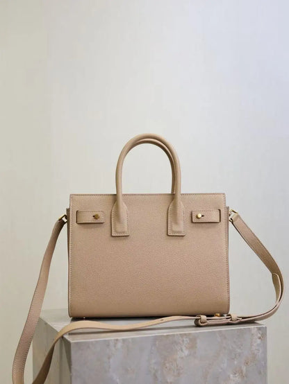 Beige handbag on a light gray surface with a neutral background