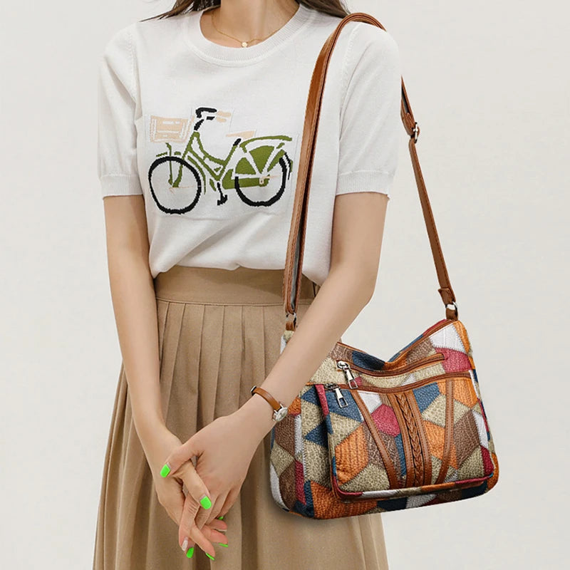 Person wearing a white t-shirt with a bicycle graphic and holding a colorful patterned handbag.