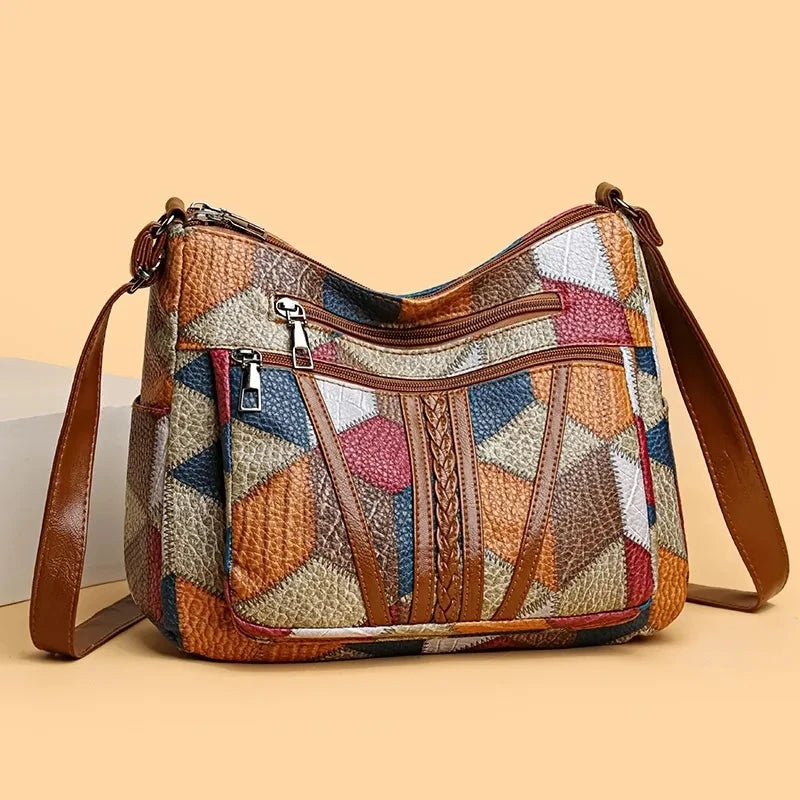 Multicolored patchwork handbag with brown leather straps on a beige background