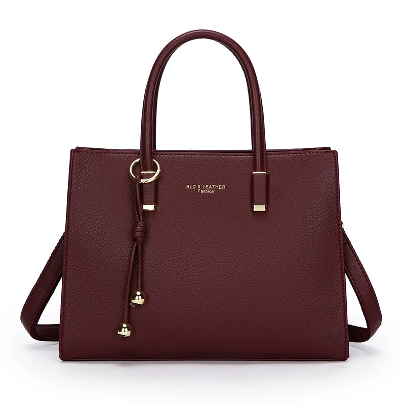 Burgundy handbag with gold accents on a white background