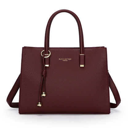 Burgundy handbag with gold accents on a white background