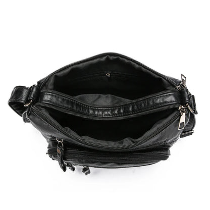 Black leather bag with multiple zippers on a white background