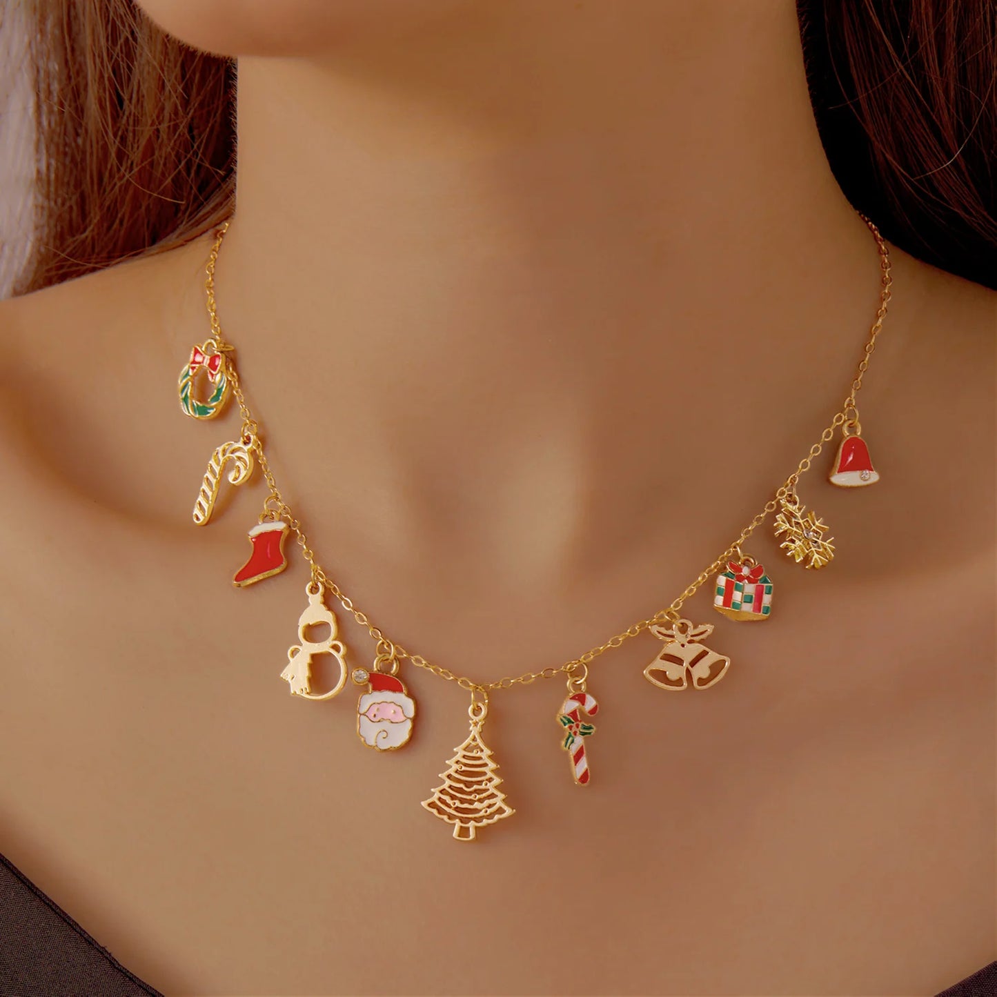 Gold necklace with festive charms on a neutral background