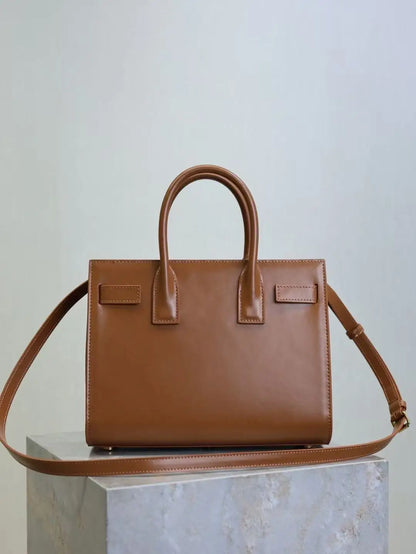 Brown leather handbag on a light gray background