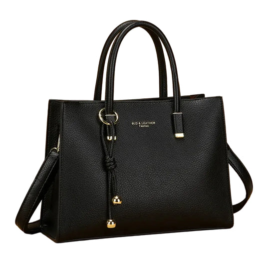 Black handbag with gold accents on a beige background, featuring the brand 'Vanderwah'.