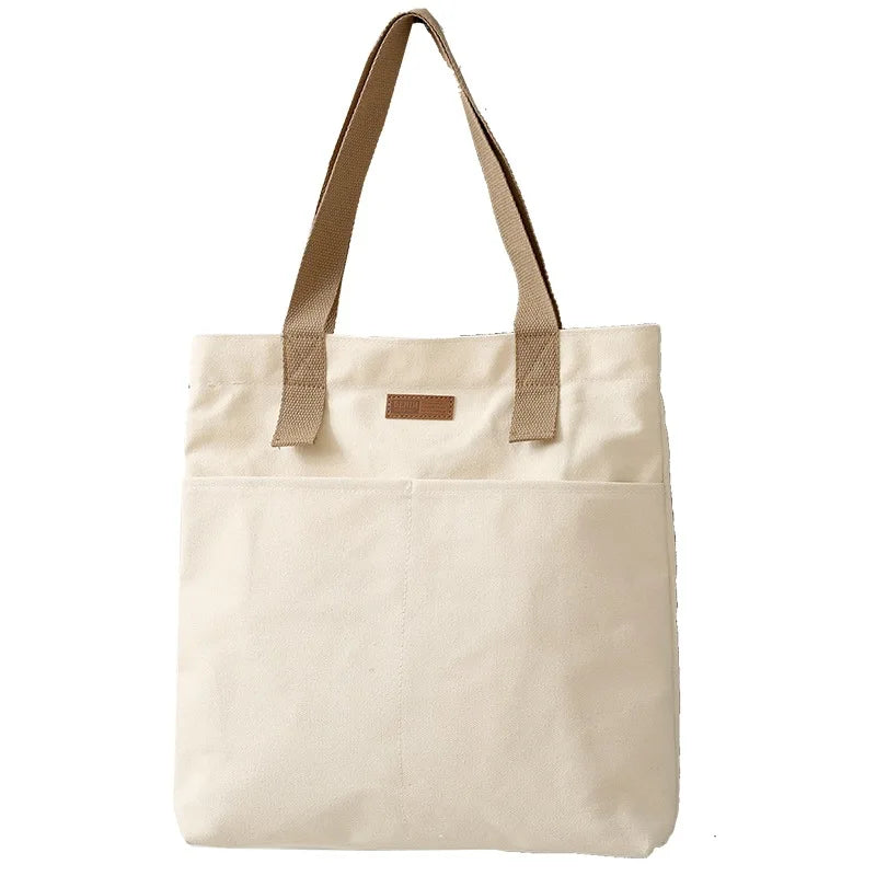 Beige tote bag with brown handles on a white background