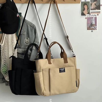 Two bags, one black and one beige, hanging on a hook against a white wall.