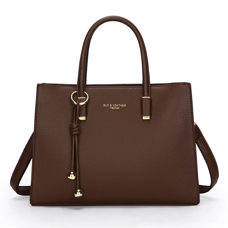 Coffee Brown leather handbag with gold accents on a white background