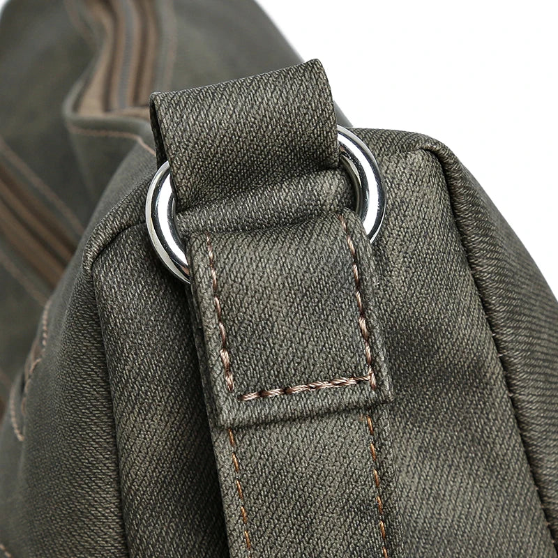 Close-up of a green backpack strap with metal ring on a blurred background