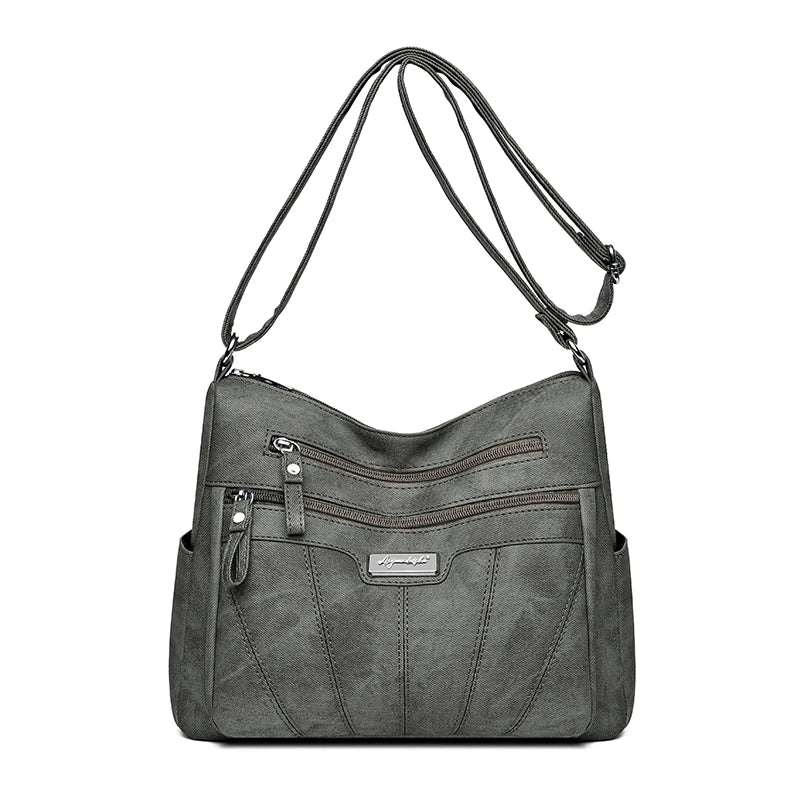 Gray shoulder bag with multiple pockets and zippers on a white background
