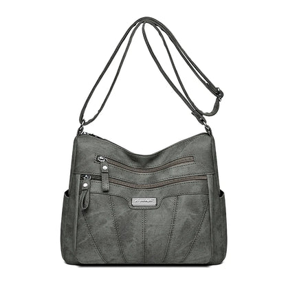 Gray shoulder bag with multiple pockets and zippers on a white background