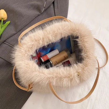 Fluffy handbag with makeup items on a textured surface