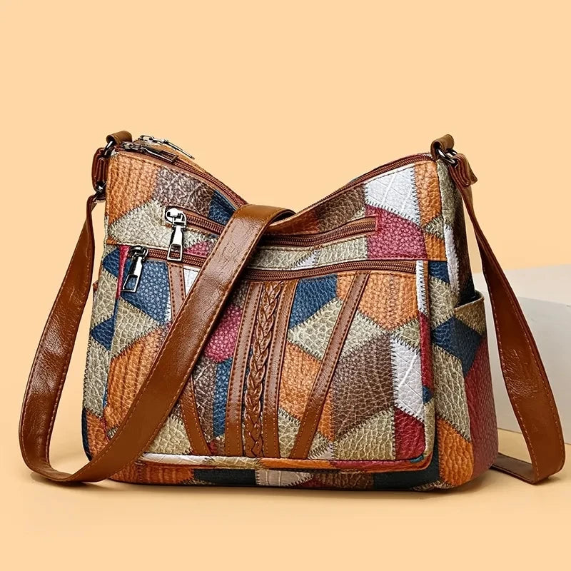 Multicolored patchwork handbag with brown leather straps on a beige background