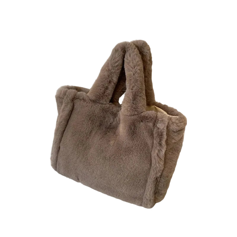 Brown fur bag on a white surface with a framed picture in the background