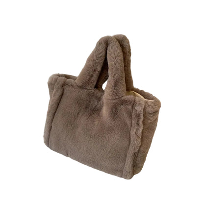 Brown fur bag on a white surface with a framed picture in the background