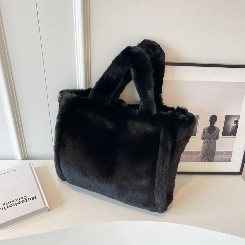 Black fur handbag on a white surface with a blurred background