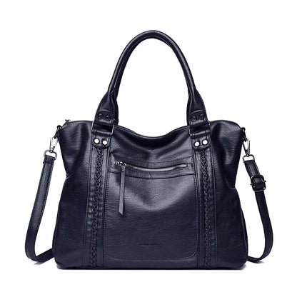 Black leather handbag with braided details on a white background