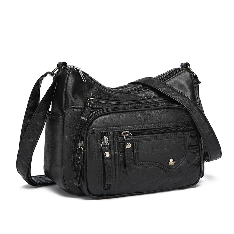 Black leather handbag with multiple pockets and zippers on a white background