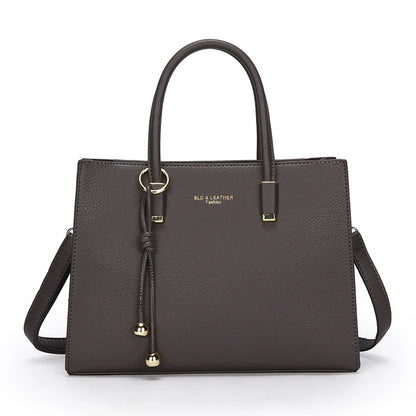 Grey leather handbag with gold accents on a white background