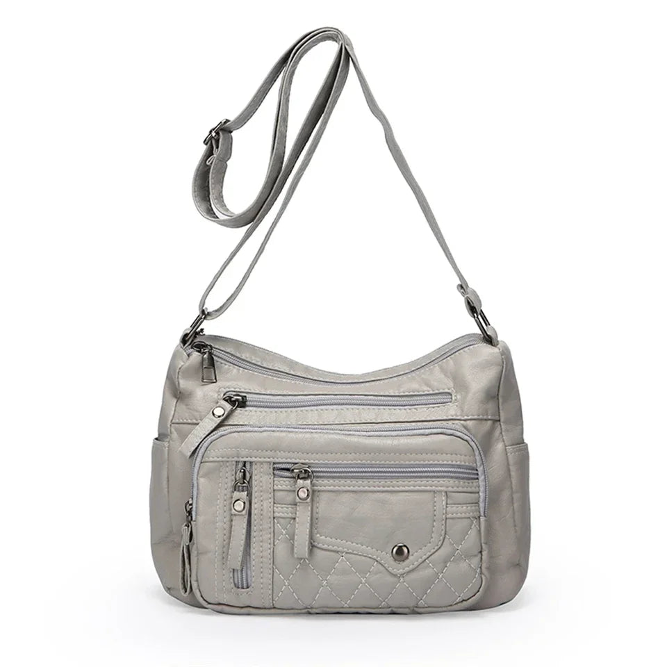 Gray shoulder bag with multiple pockets and zippers on a white background