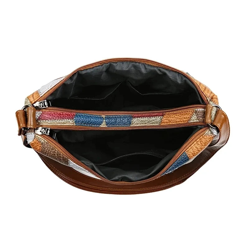 Brown leather handbag with colorful striped handle on a white background