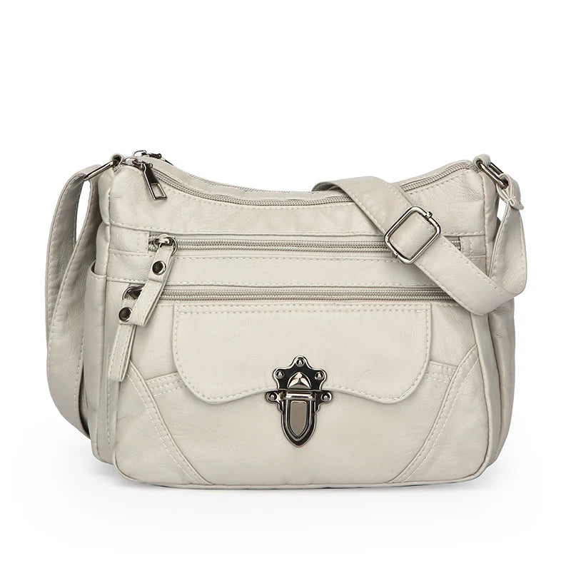 Beige handbag with a decorative clasp on a white background