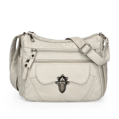 Beige handbag with a decorative clasp on a white background