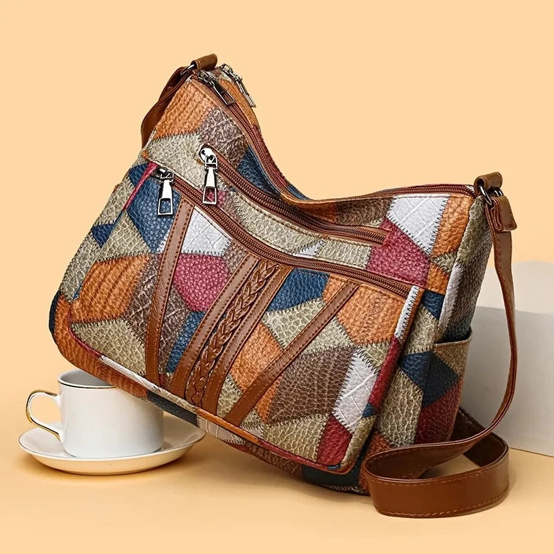 Multicolored patchwork handbag with brown leather accents on a beige background