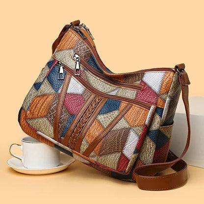 Multicolored patchwork handbag with brown leather accents on a beige background