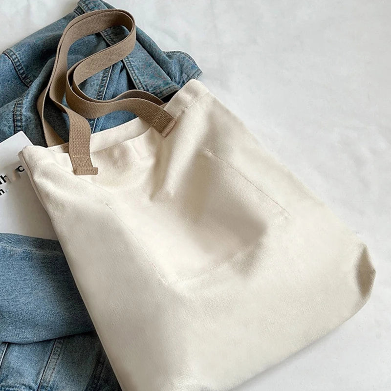 Beige tote bag with brown straps on a white surface
