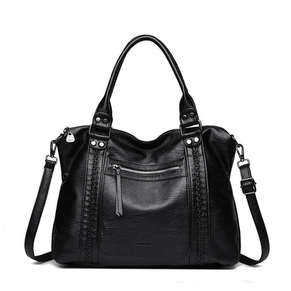 Black leather handbag with multiple pockets and straps on a white background